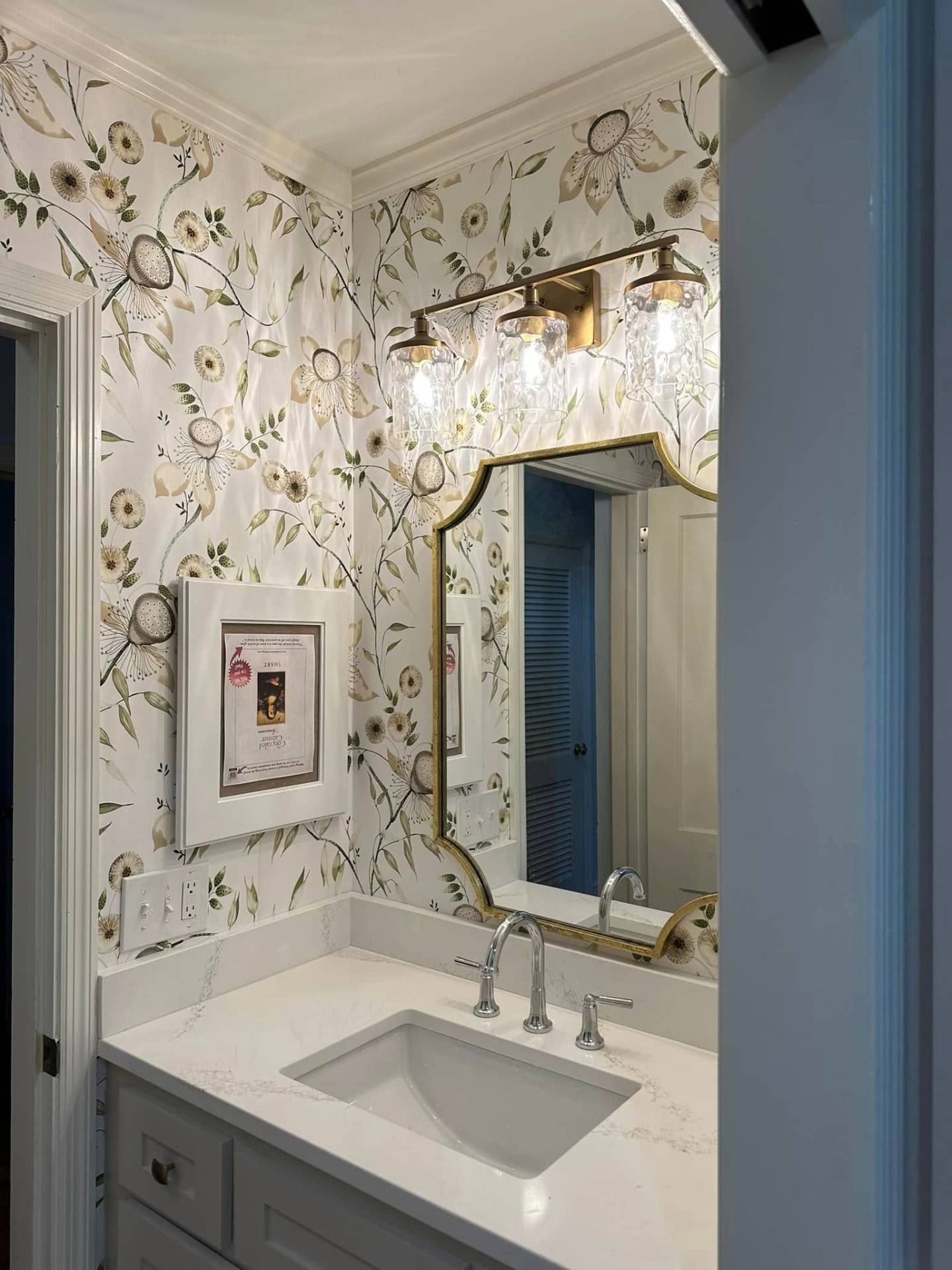 Bathroom after - floral wallpaper with brass fixtures